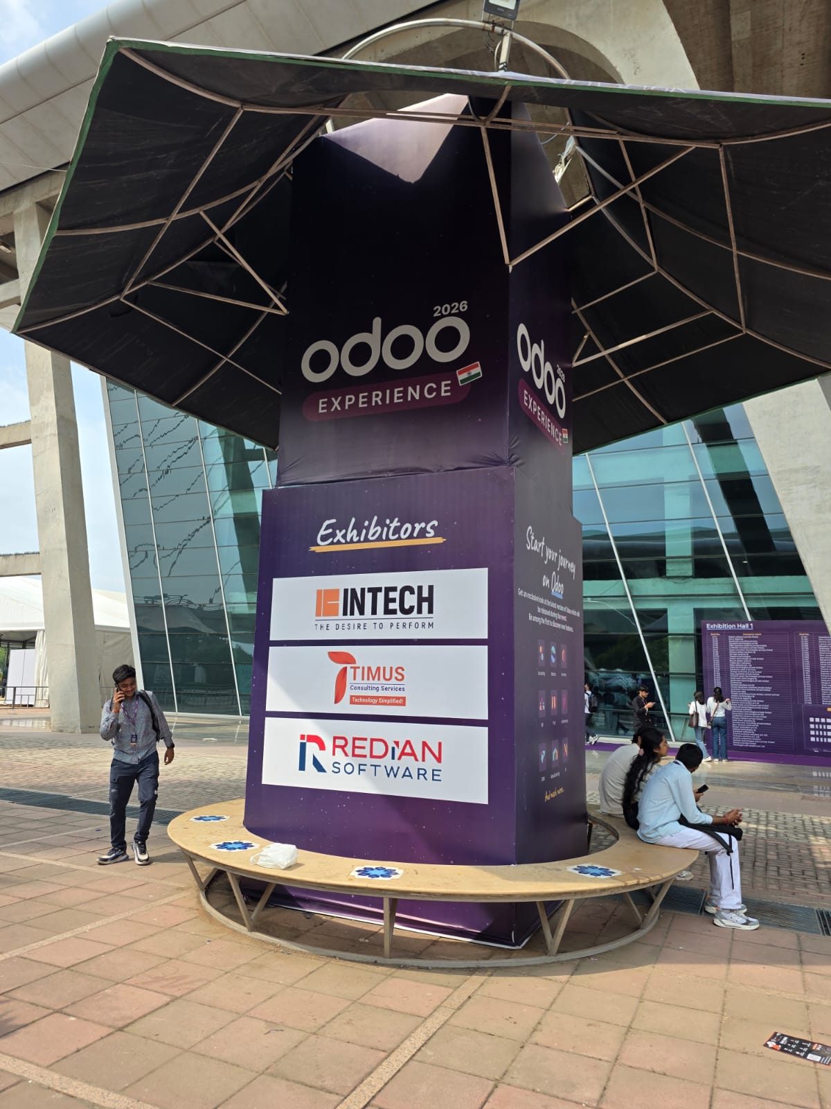 Odoo Experience 2026 exhibitors pillar at the venue entrance with Redian Software listed alongside Intech and Timus Consulting