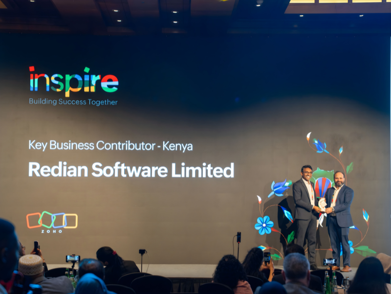 Redian Software award ceremony moment at Zoho Inspire MEA 2026 showing team holding Key Business Contributor trophy for Kenya with Dubai skyline backdrop